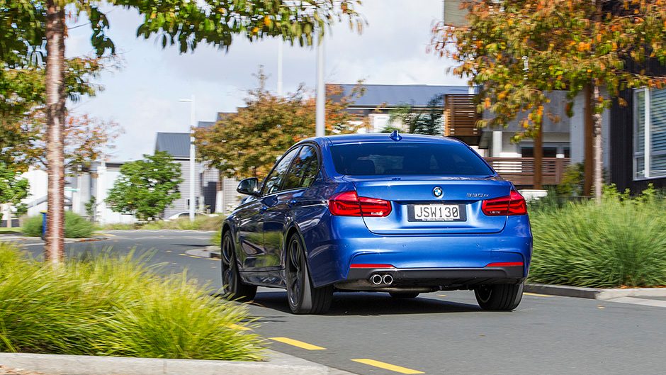 2016 BMW 330e driving past houses