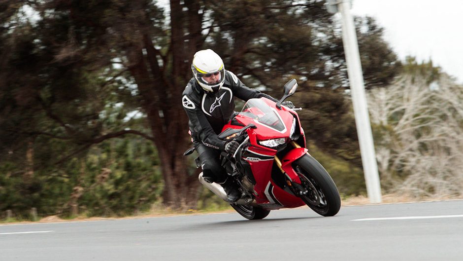 2017 Honda CBR1000RR riding past trees