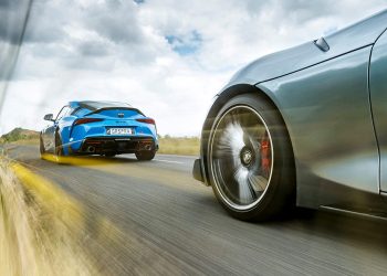 Two Toyota GR Supras driving on road