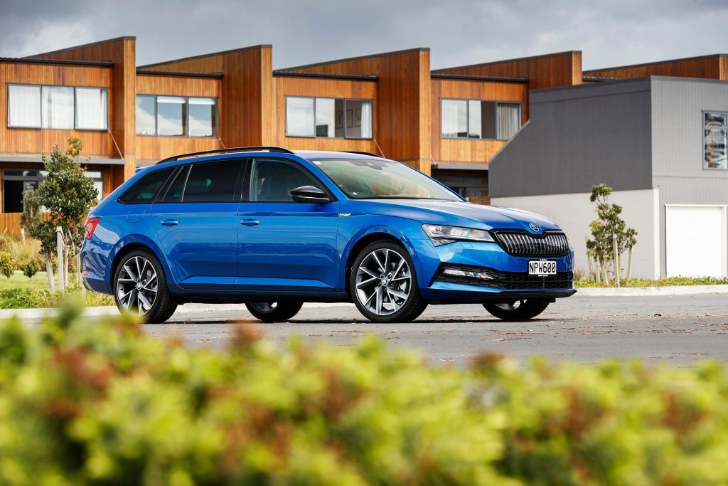 Skoda Superb iV Sportline parked in front of houses