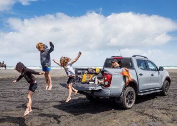 Kids jumping off back of Nissan Navara at Muriwai Beach