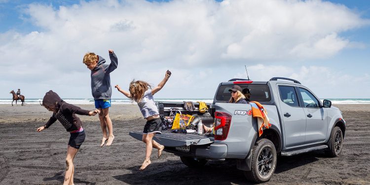 Kids jumping off back of Nissan Navara at Muriwai Beach