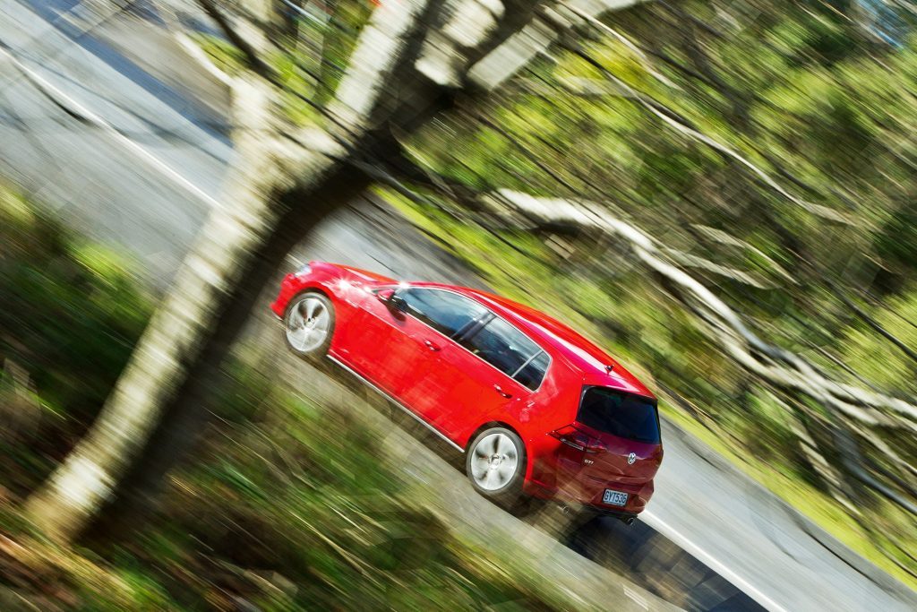 2013 VW Golf GTI driving past trees
