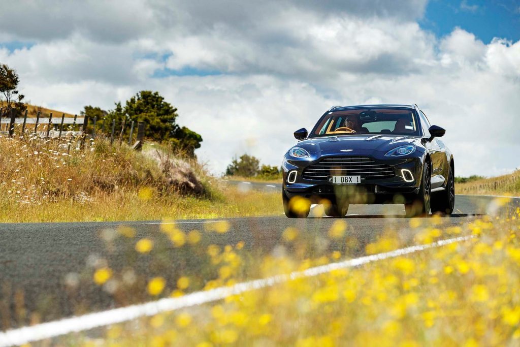 2022 Aston Martin DBX on road with flowers in foreground