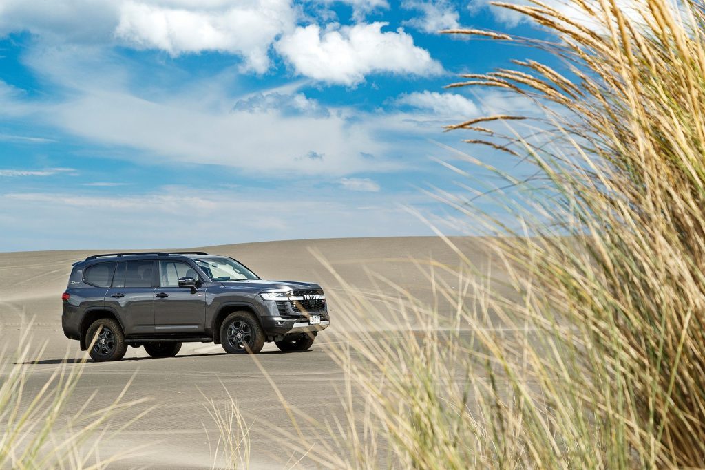 2021 Toyota Land Cruiser 300 GR Sport parked on dunes with grass in foreground