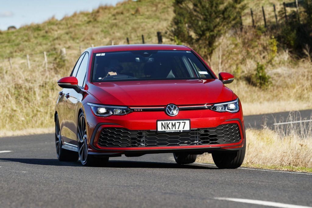 Volkswagen Gold GTI driving around corner on country road