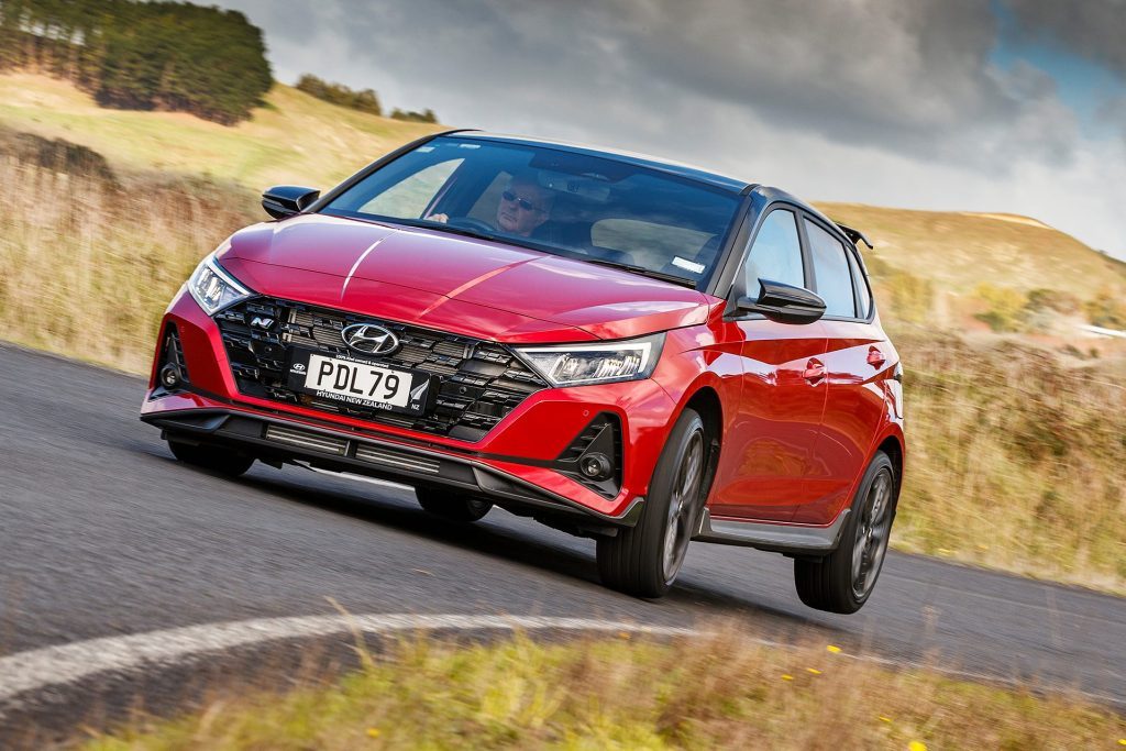 red Hyundai i20 N lifting a rear wheel