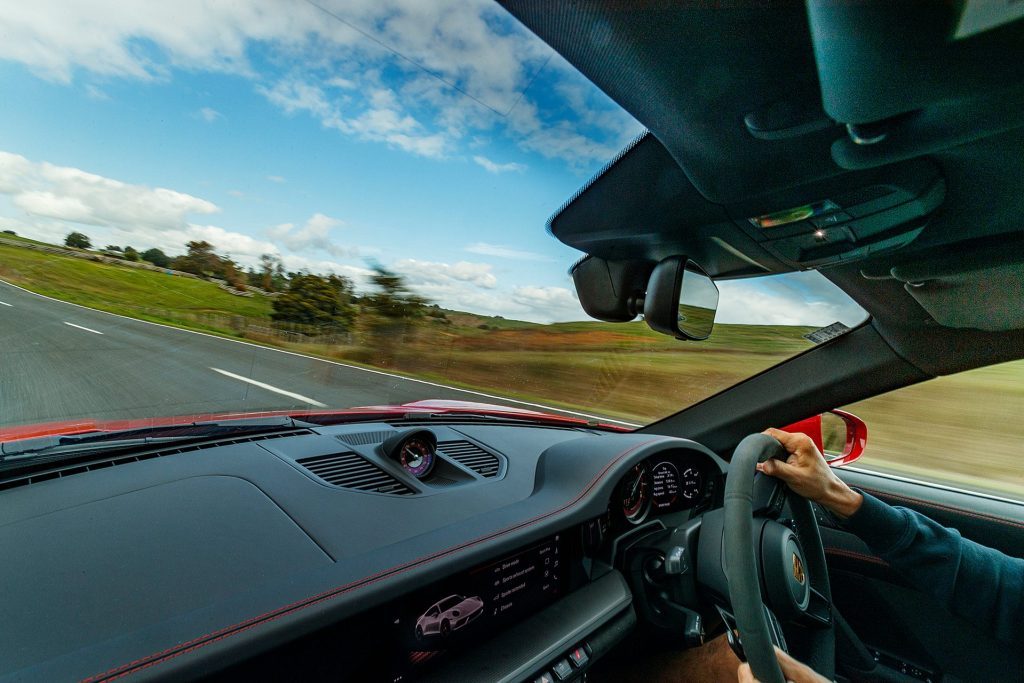 red Porsche 911 GTS driving action