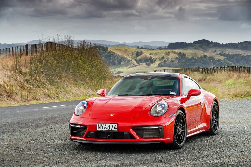 red Porsche 911 GTS front static in countryside