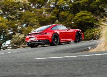 Porsche 911 GTS driving around corner at speed