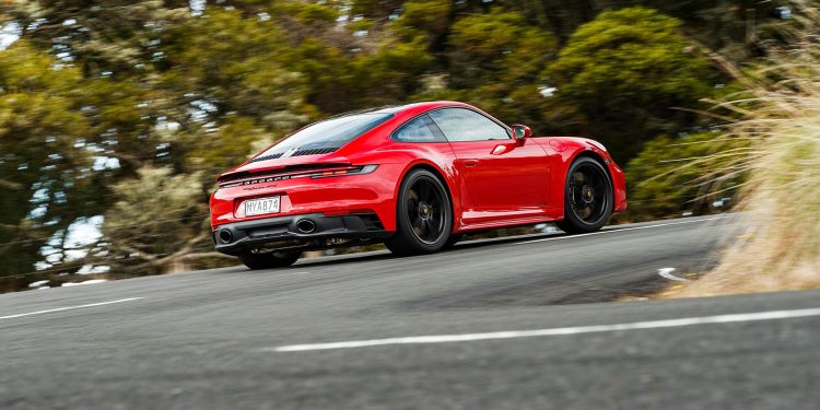 Porsche 911 GTS driving around corner at speed