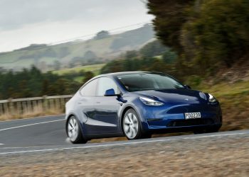 Tesla Model Y front three quarter view driving on road