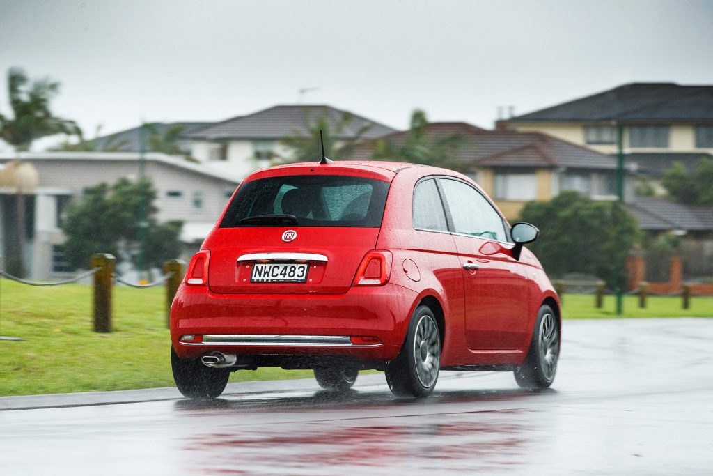 Fiat 500 Dolcevita driving past houses