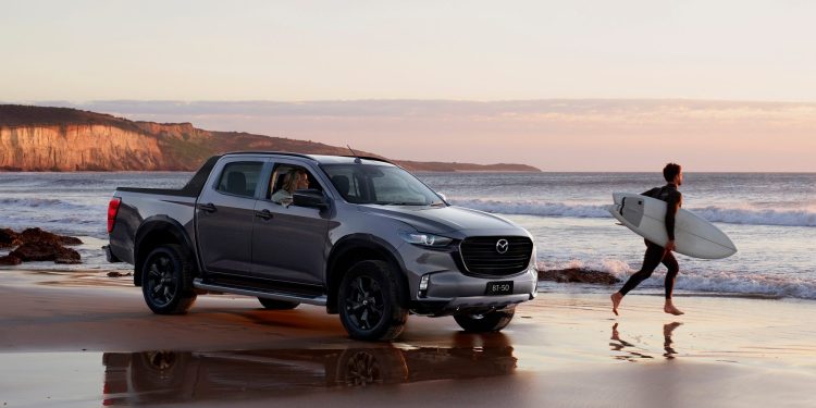 Mazda BT-50 front three quarters on beach with surfer