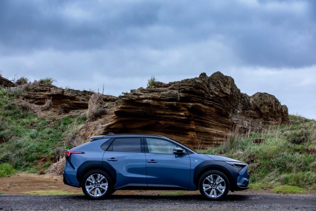 Subaru Solterra side profile with rock formations