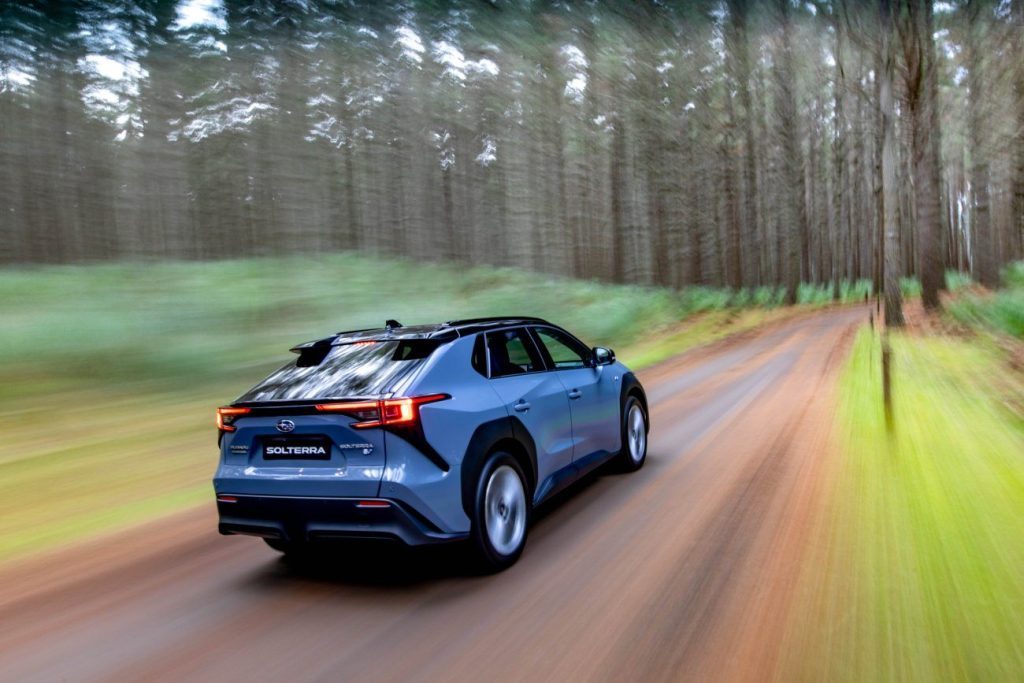 Subaru Solterra driving through forest