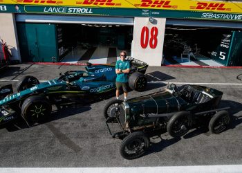 Sebastian Vettel standing between AMR22 Formula 1 car and 1922 Aston Martin TT1 Green Pea
