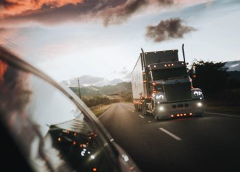 Freightliner Coronado being overtaken by car front three quarters