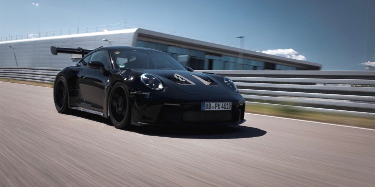 Porsche 911 992 GT3 RS driving on track front three quarters