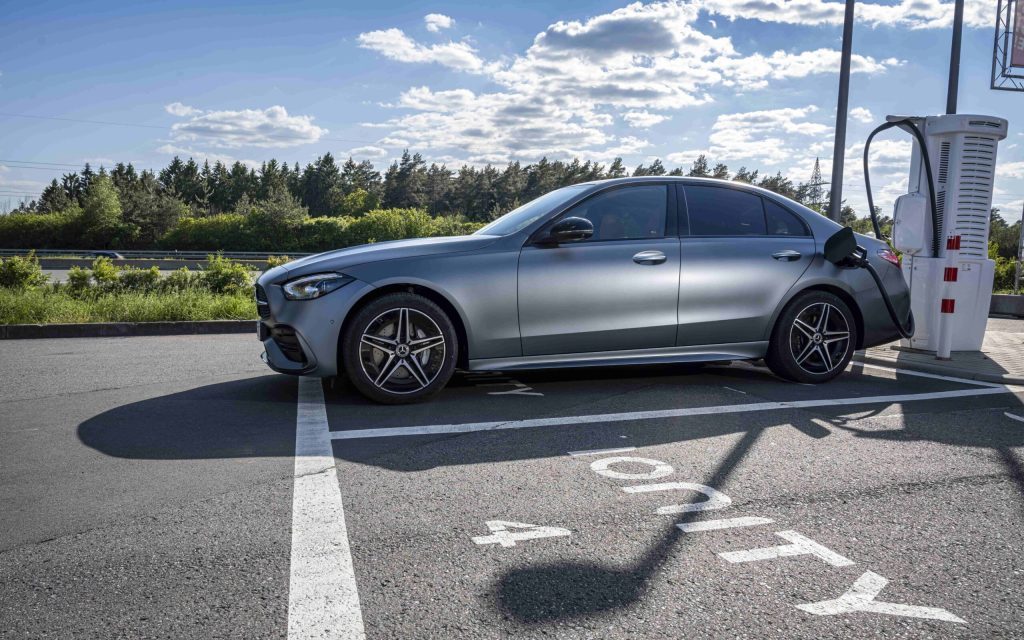 Mercedes-Benz C 350 e side view at electric vehicle charger