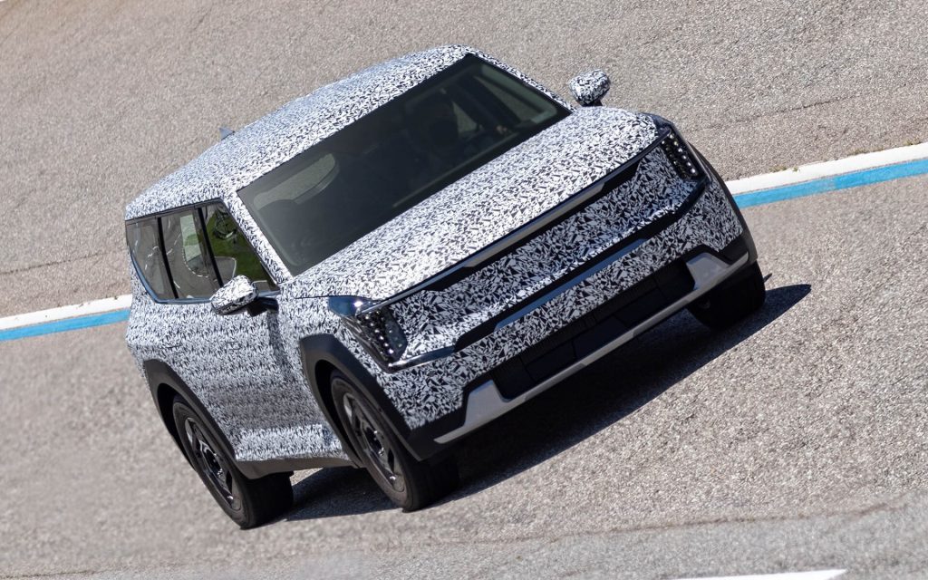 Kia EV9 in camouflage driving on test track