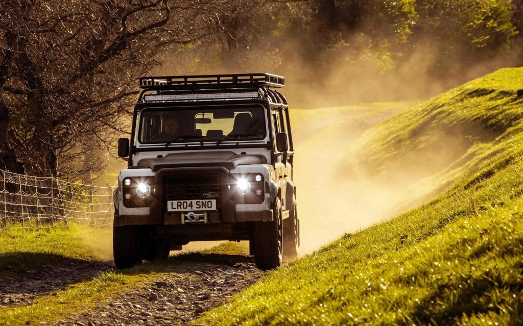 Land Rover Defender Works V8 Trophy II front view driving on gravel road