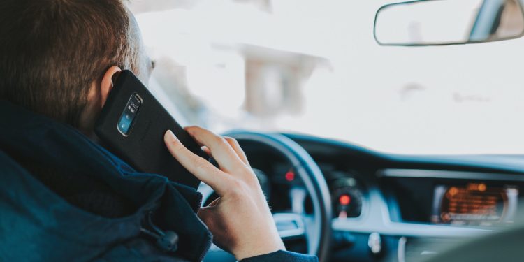 Man using phone while driving car