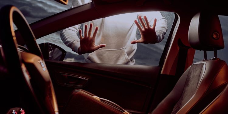 Person looking into car at night