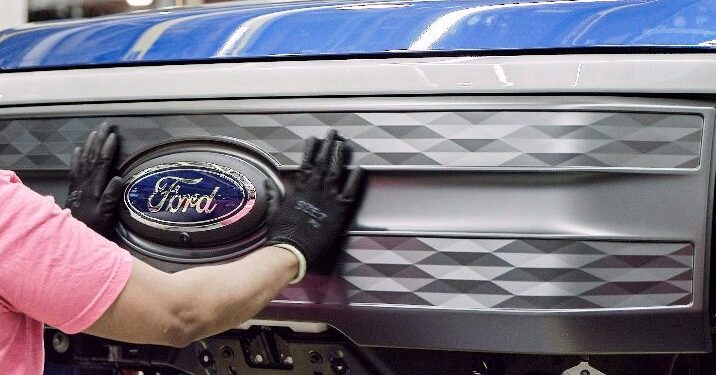 Ford badge being applied to F150 Lightning by worker