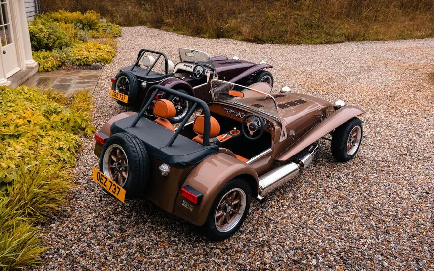 Two Caterham Super Sevens parked next to each other rear three quarter view