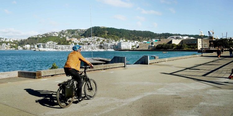 Man riding bike by water