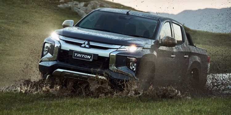 Mitsubishi Triton driving through mud off road front view