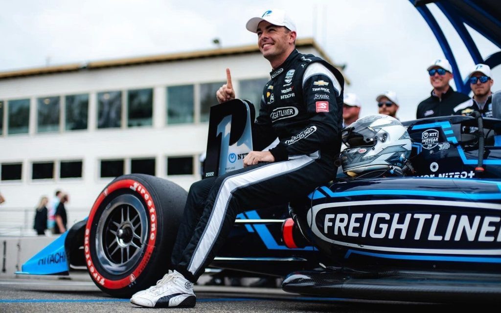 Scott McLaughlin sitting on IndyCar with first place trophy in Portland