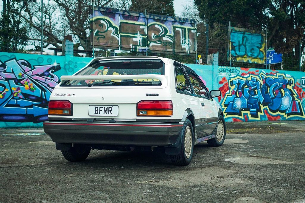 1986 Mazda Familia 4x4 DOHC Turbo in front of artwork