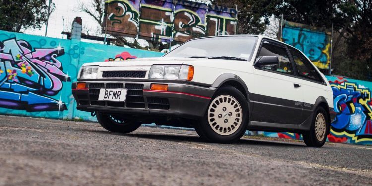 1986 Mazda Familia 4x4 DOHC Turbo in front of street art