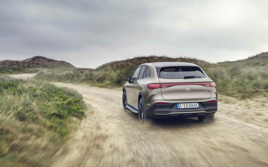 Mercedes EQE SUV rear view driving on dirt road