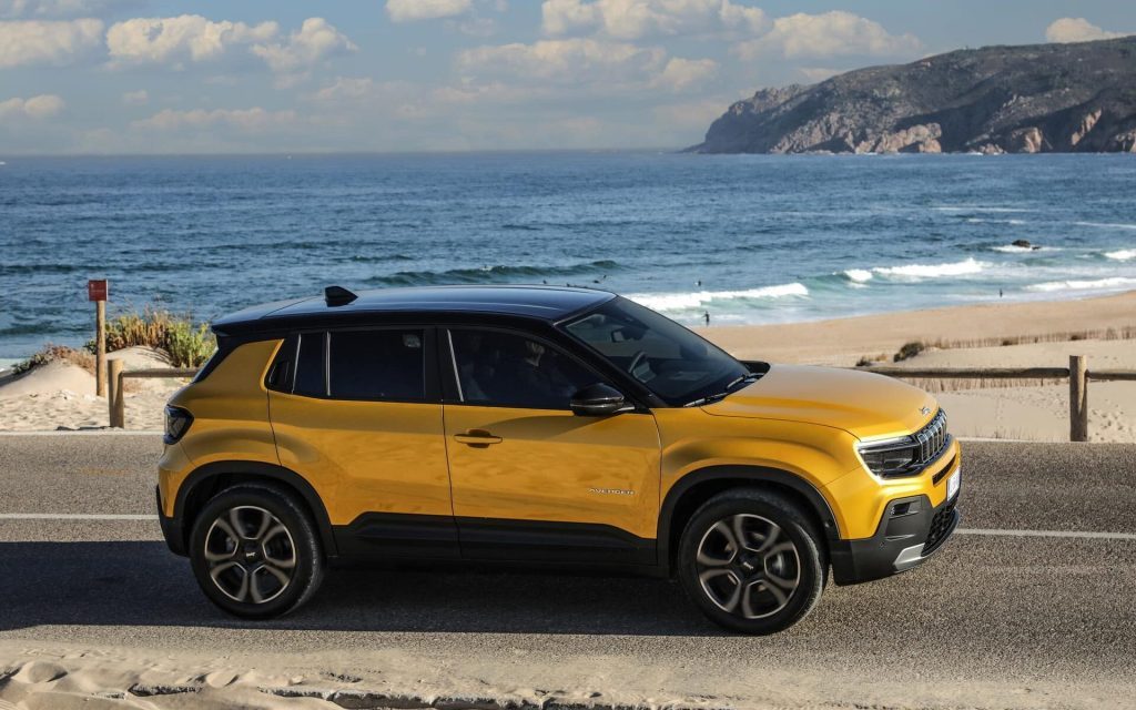 Jeep Avenger side view driving by beach