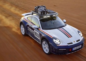 Porsche 911 Dakar driving off road high angle front three quarter view