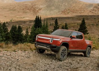 Rivian R1T front three quarter view on dirt trail