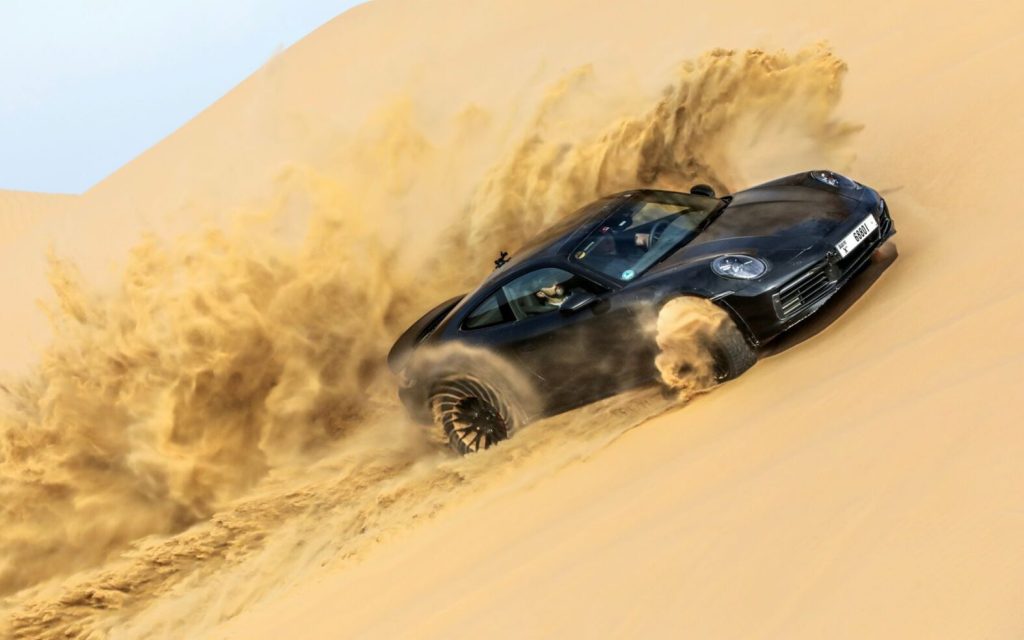 Porsche 911 Dakar driving up sand dune