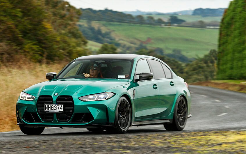 BMW M3 Competition front three quarter view driving around corner
