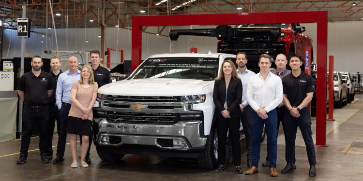 GMSV workers standing next to Chevrolet Silverado remanufacturing line