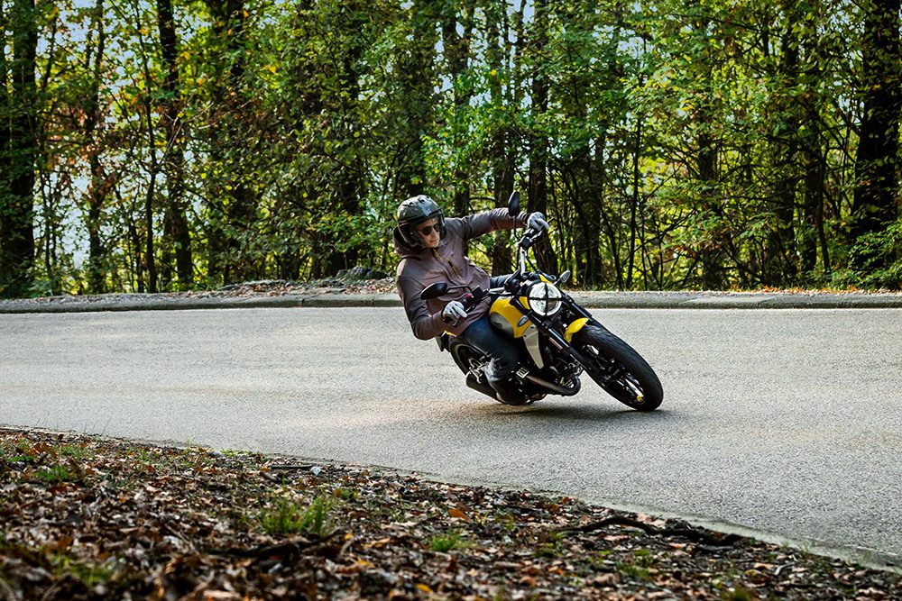 Ducati Scrambler riding past trees