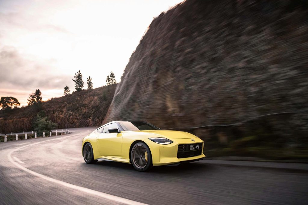 Nissan Z Coupe driving past cliff face