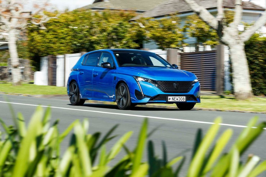 Peugeot 308 GT driving down street