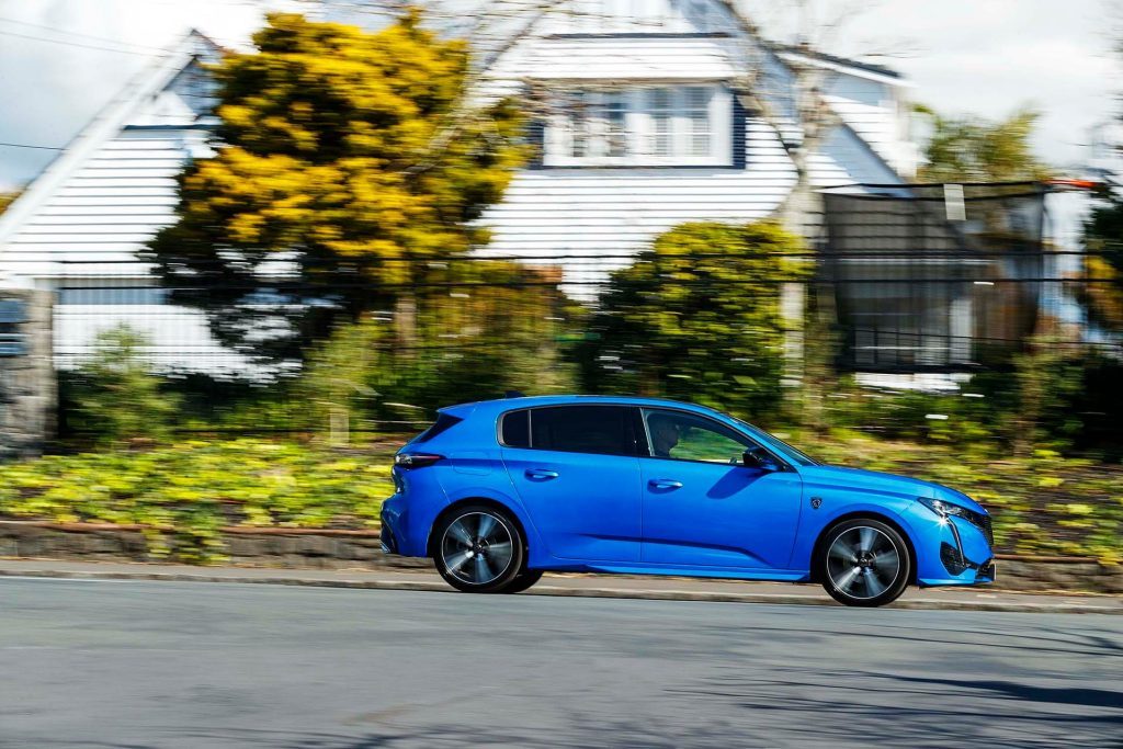 Peugeot 308 GT driving past house