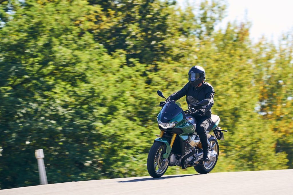Moto Guzzi V100 Mandello riding past trees