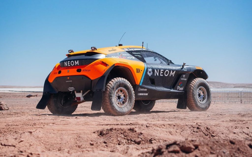 Extreme E race car rear three quarter view on dirt