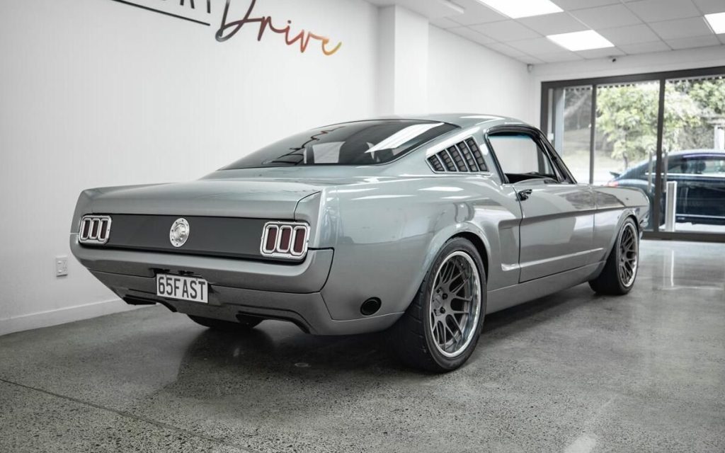 1965 Ford Mustang Fastback rear three quarter view in dealership