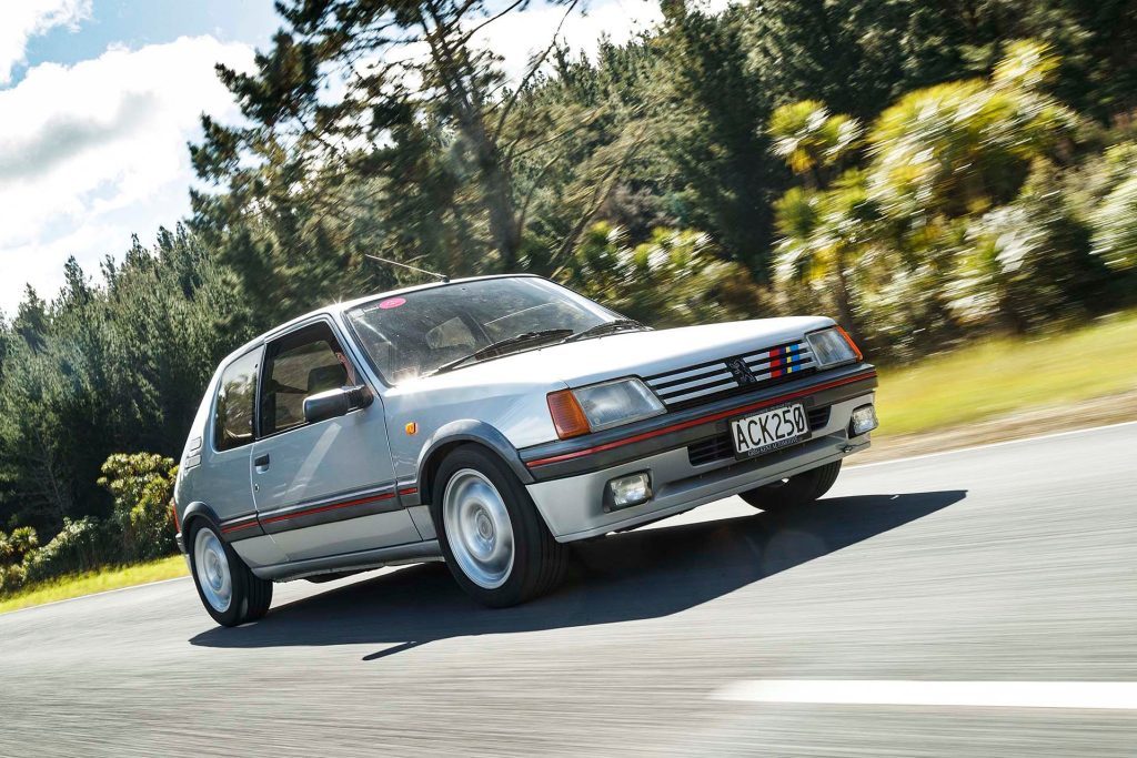 Peugeot 205 GTi driving past trees